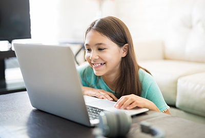 Little student girl with laptop pc at home